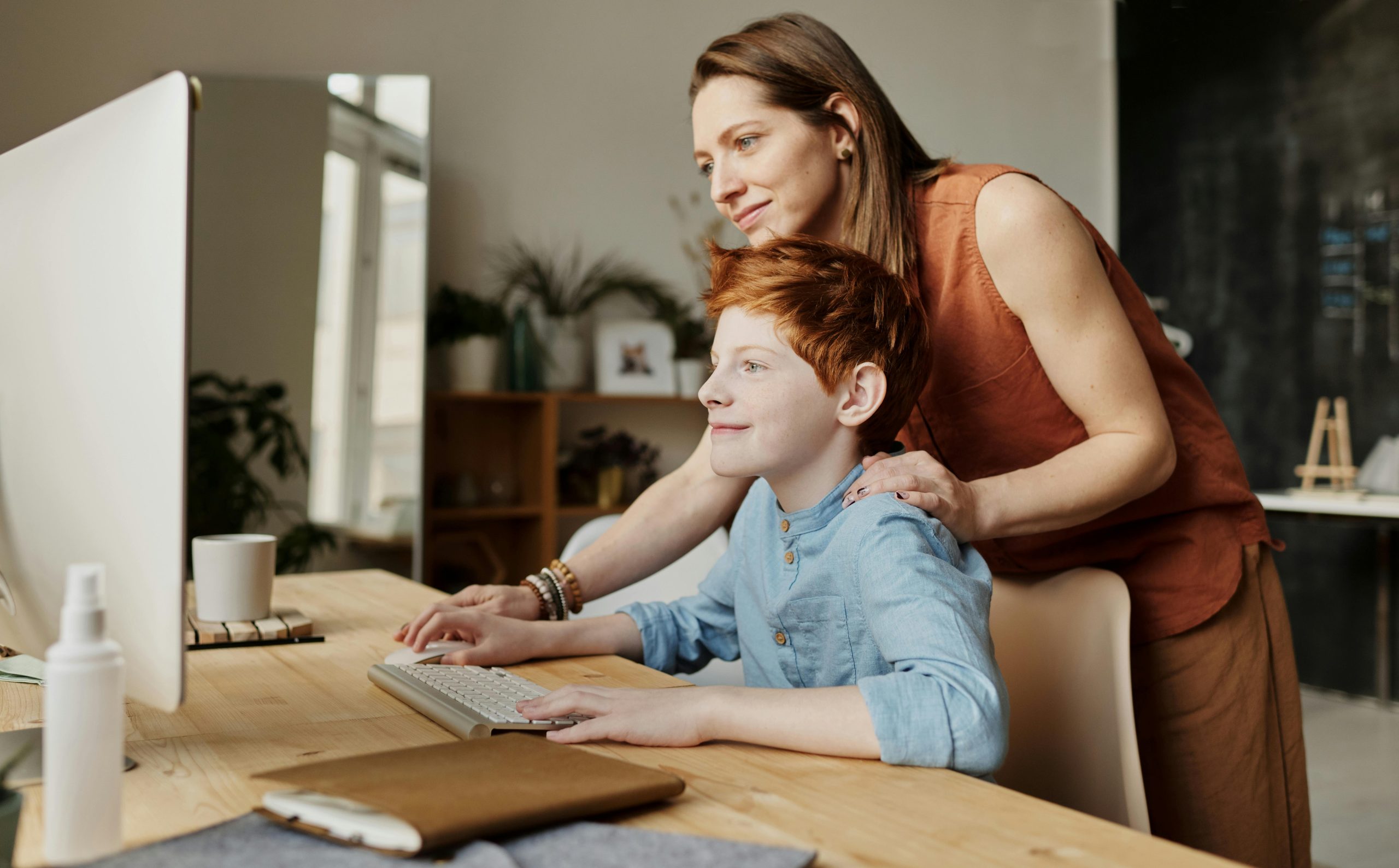 kid is looking at services behind computer
